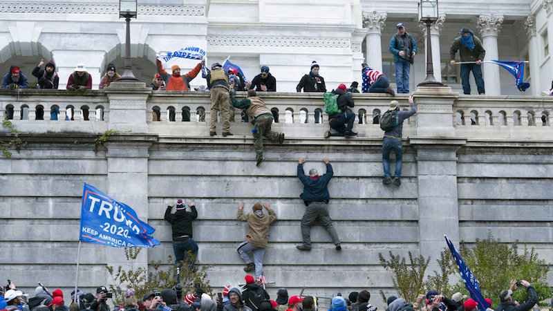 Guys scaling the walls of the United States Capitol.